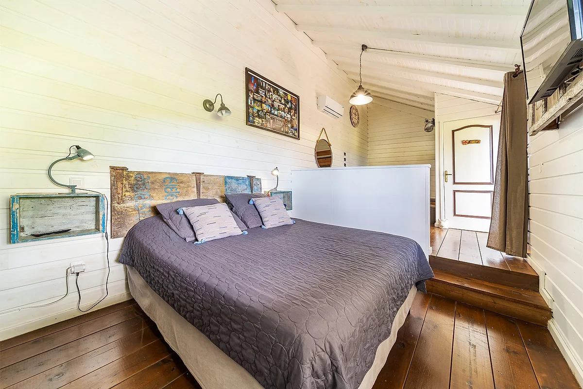 La Case, grande chambre lambrissée de bois clair
