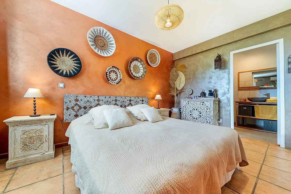La chambre Volcan, son mur orange et ses paniers tressés